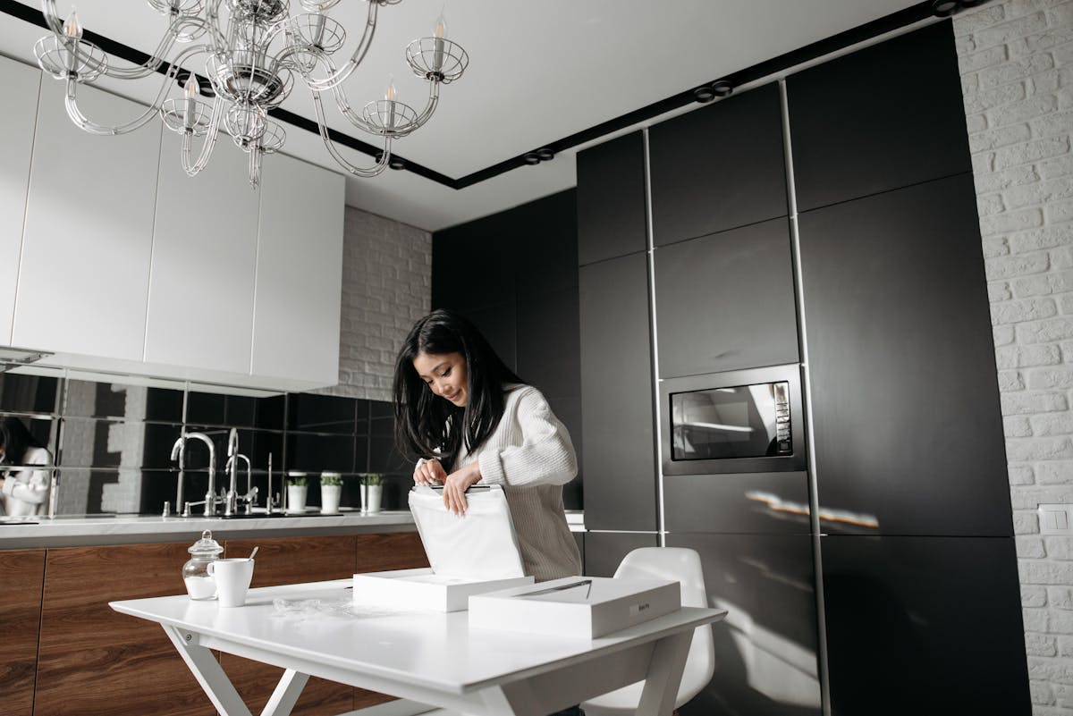 Qual é a melhor forma de usar empréstimo consignado para comprar eletrodomésticos? Woman in White Sweater Opening the Package on the Table