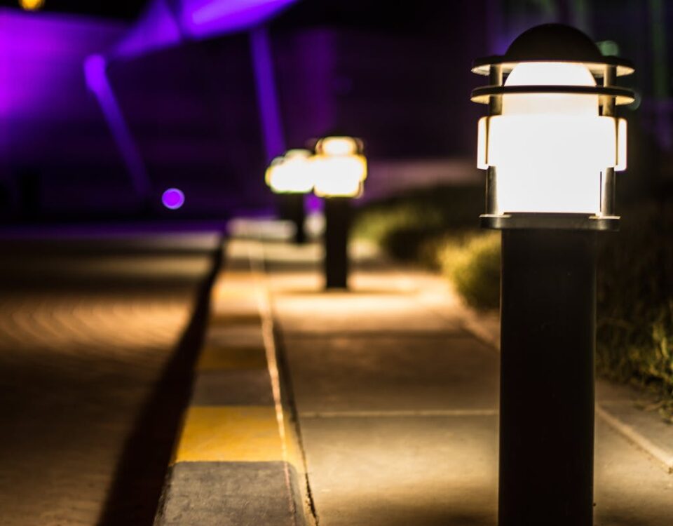 Equipamentos de automação para valorização de apartamentos A scenic night view of illuminated lamp posts lining a paved path with a bokeh effect.