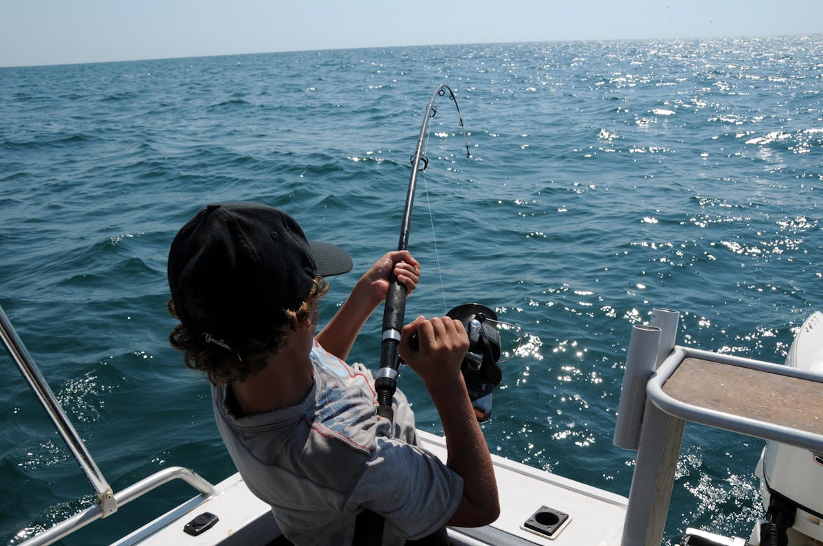 Como escolher o sonar de pesca ideal: Dicas e especificações A young man actively fishing in the ocean near Broome, WA, enjoying a sunny day.
