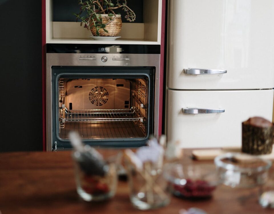 Tipos de motores em eletrodomésticos e suas aplicações A warm kitchen scene featuring an open oven and a wooden table in a cozy home setting.