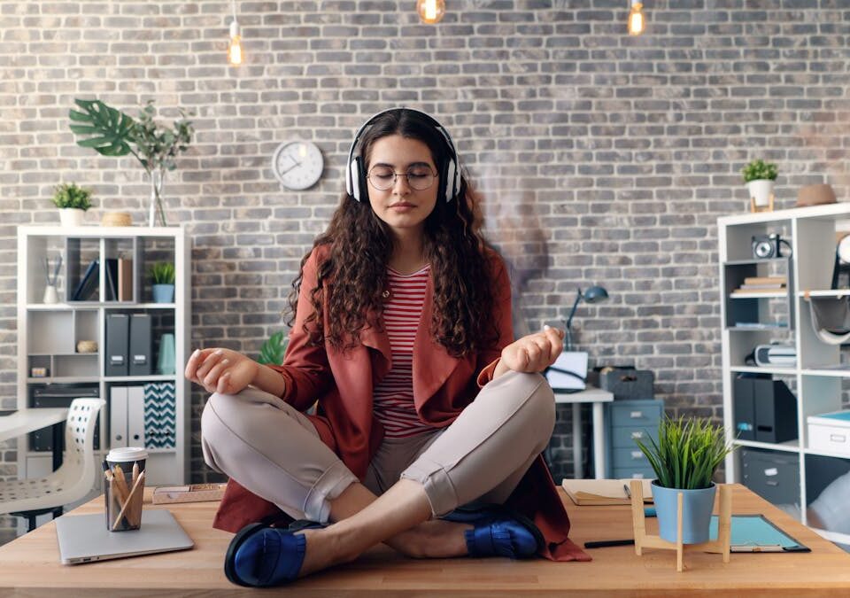 Ferramentas eletrônicas que melhoram o conforto diário A woman sitting in meditation in a room with a laptop