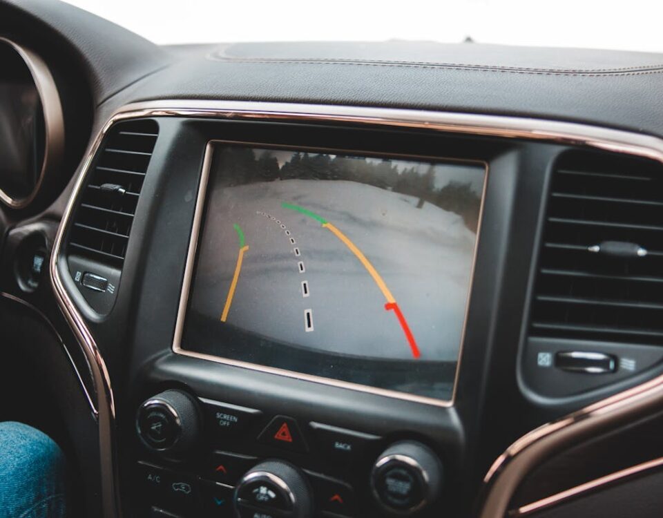 Close-up of a car's dashboard showing a rearview camera display for parking assistance.