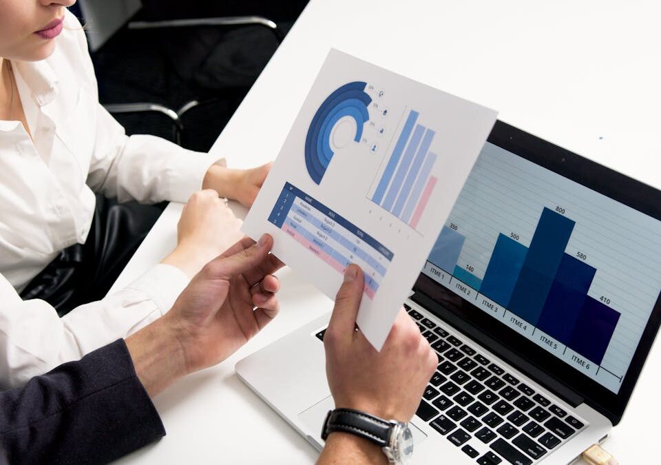 Business professionals discussing data charts and graphs in a modern office setting.