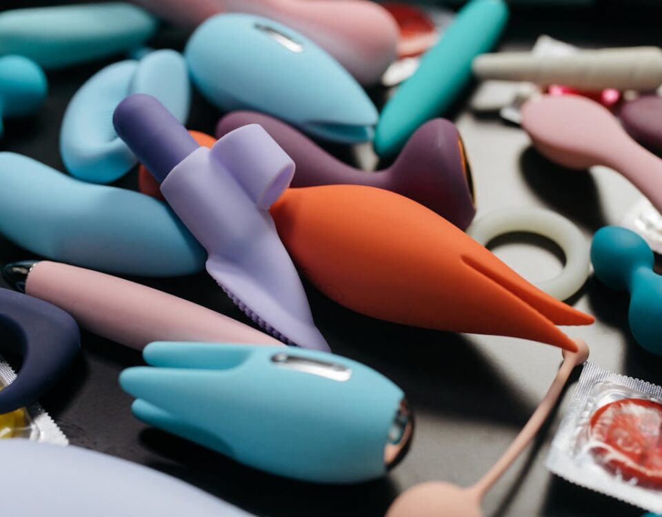 Aparelhos eletrônicos mais procurados em sex shops An array of vibrant adult toys including vibrators and rings in a close-up view.