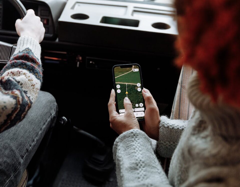 Two people using a navigation app on a smartphone during a road trip