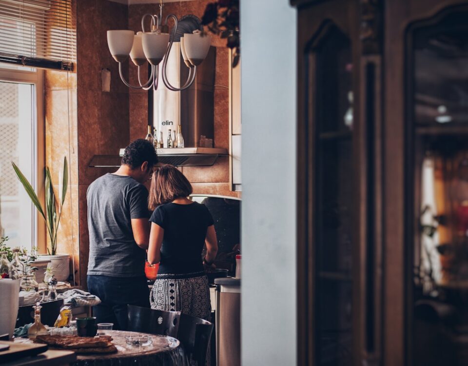 man and woman standing in front of gas range