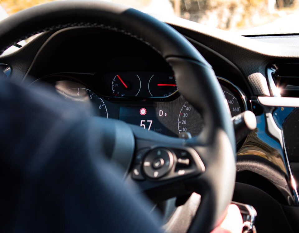Close-up view of a car dashboard and steering wheel, featuring a digital speedometer display.