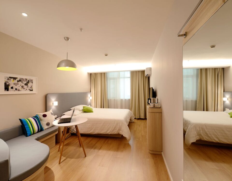 Spacious modern hotel room featuring cozy decor and neutral tones with natural light.