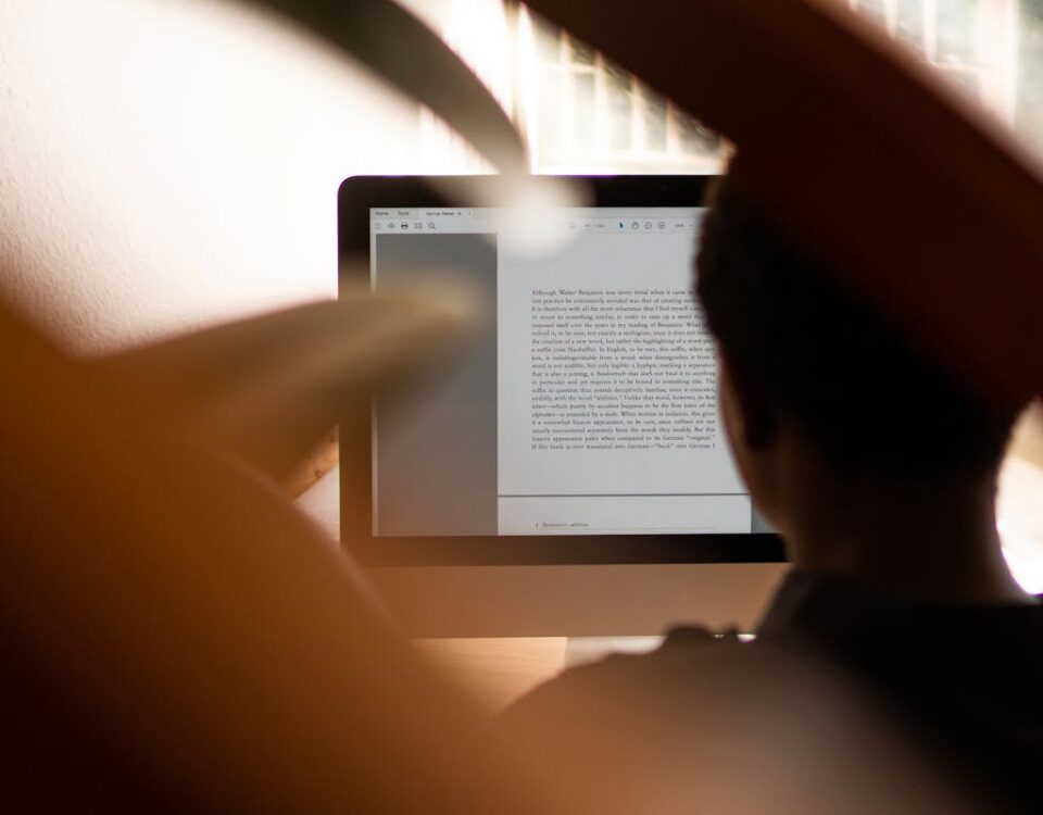 Silhouette of a person working from home on a computer, highlighting remote work lifestyle.