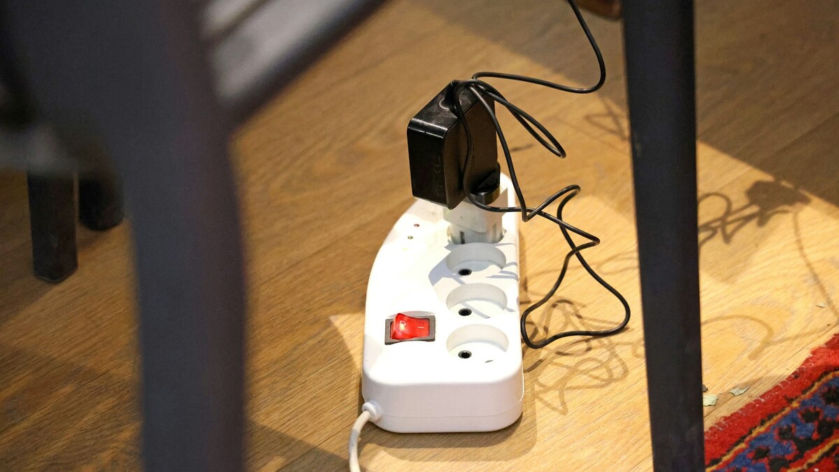 Filtro de linha branco com plugues conectados sobre o piso