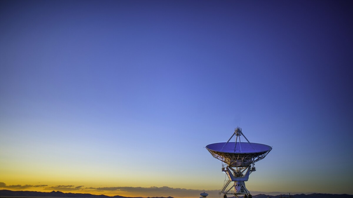 Antena parabólica cinza instalada em um campo aberto