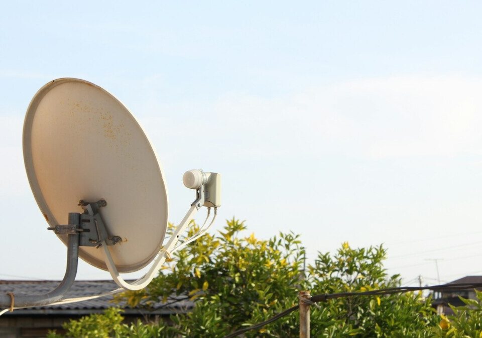 Antena parabólica fixada na parede de uma casa