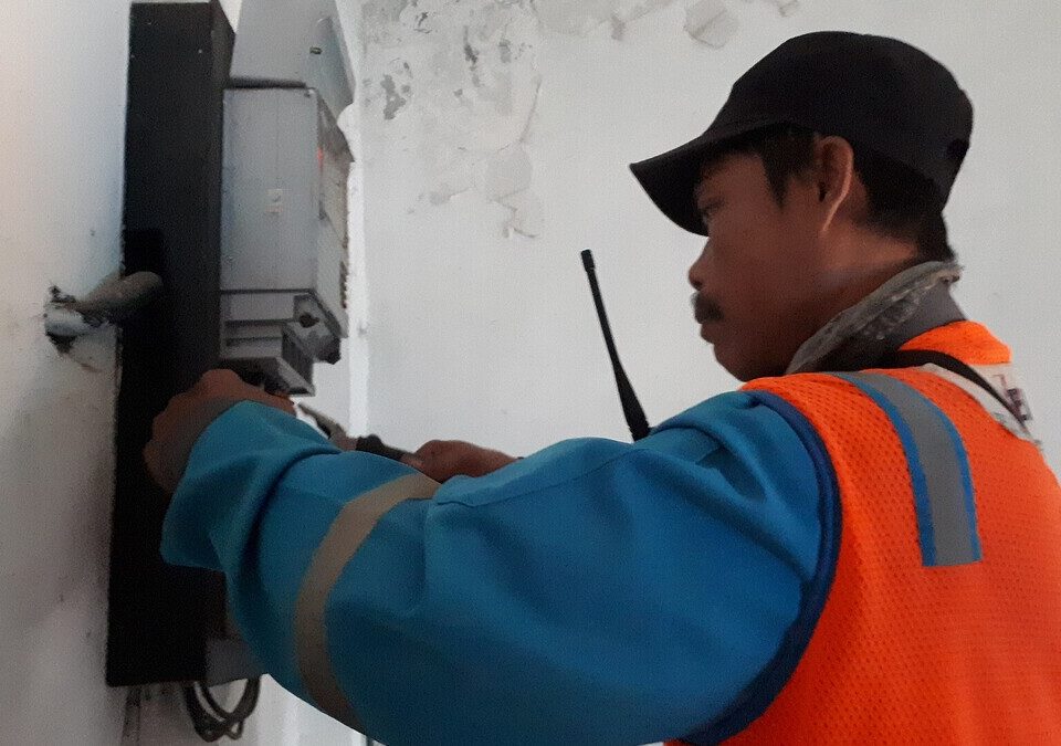 Eletricista fazendo reparo em medidor de energia na parede
