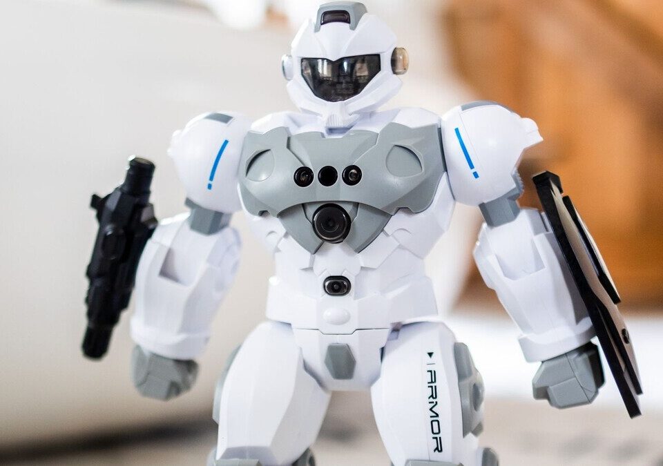 Robô de brinquedo branco com sensores no peito sobre um tapete