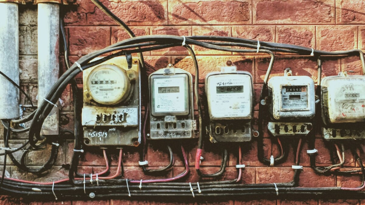 Fileira de medidores de energia antigos presos a uma parede de tijolos