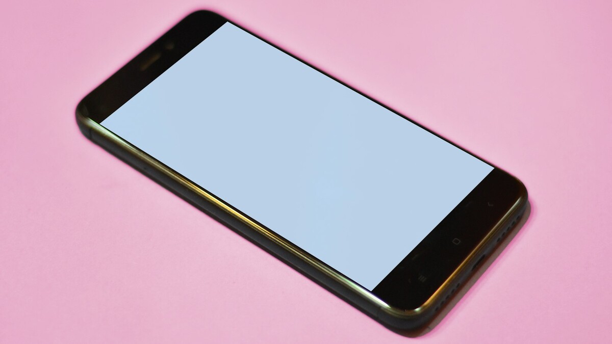 Por que o link do WhatsApp abre no navegador e não no aplicativo? Smartphone Android preto com tela apagada sobre fundo rosa