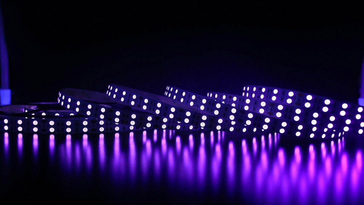 Fitas de LED acesas em fileiras sobre fundo escuro