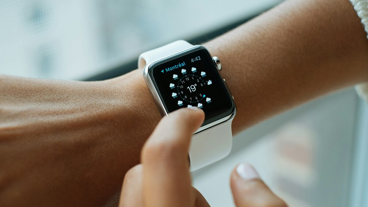 Pessoa tocando a tela de um smartwatch no pulso