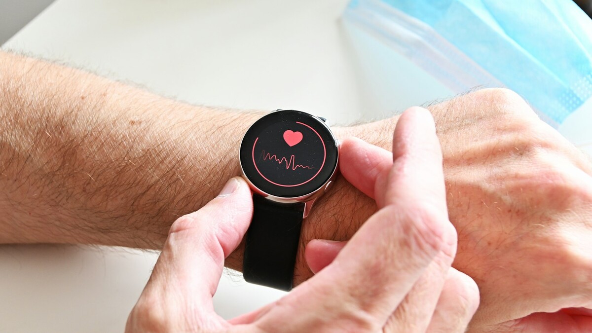 Pulso com smartwatch exibindo ícone de coração e frequência cardíaca
