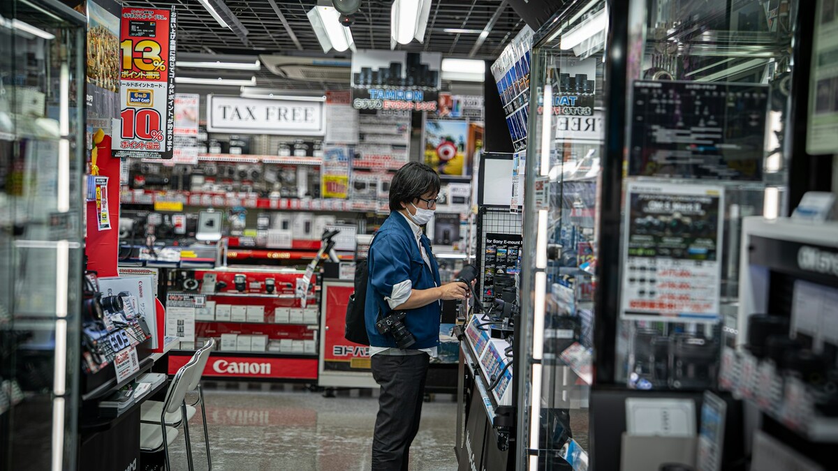 Pessoa observando produtos eletrônicos em uma loja iluminada